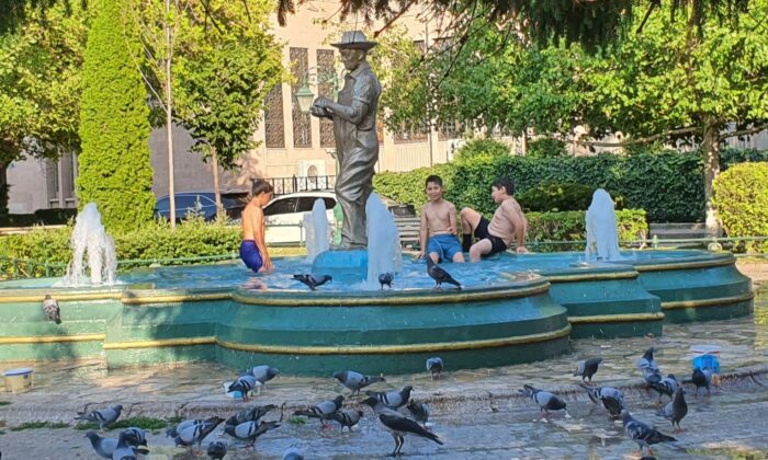 Sıcaklardan bunalan çocuklar süs havuzuna girerek serinlemeye çalıştı